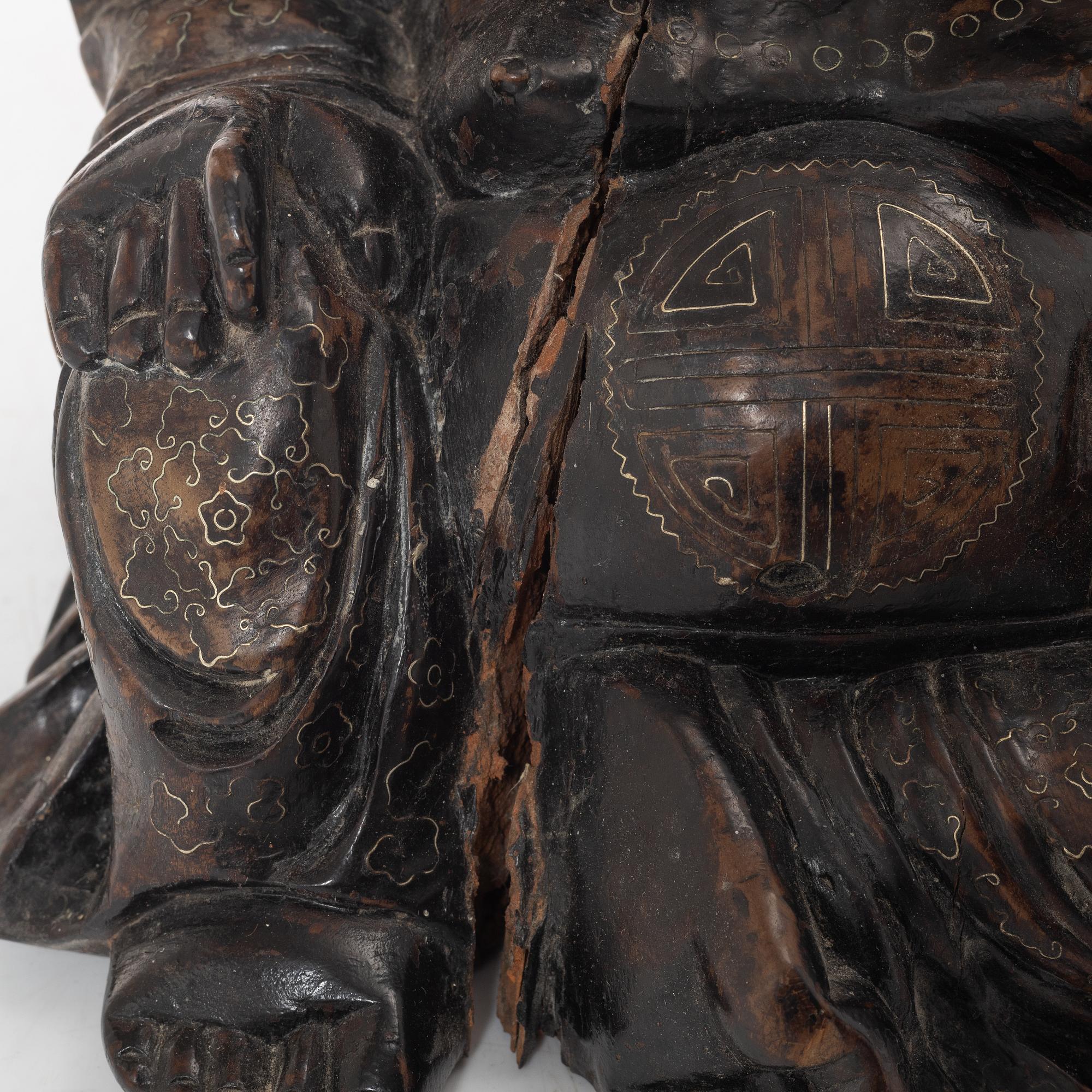 A Chinese wooden figure of Budai with silver inlays, Qing dynasty (1644-1912).