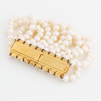 A nine strand cultured fresh water pearl bracelet with  clasp in 18K gold.