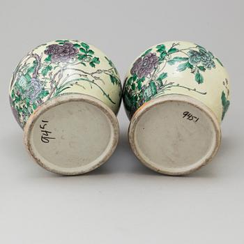 A pair of Chinese famille verte vases with covers, 20th century.