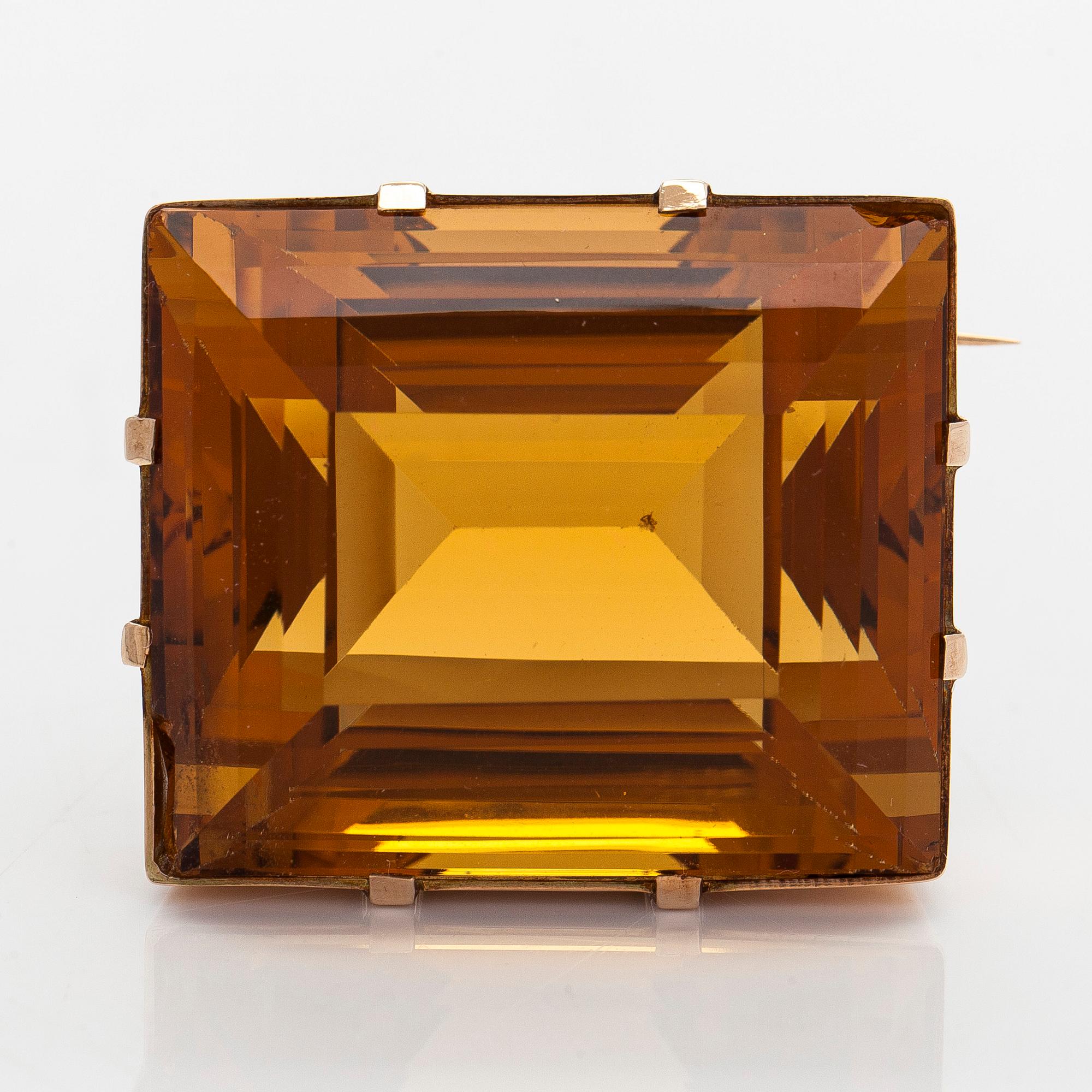 A ca 13K gold brooch, set with a step-cut Madeira citrine approximately 119.0 ct.
