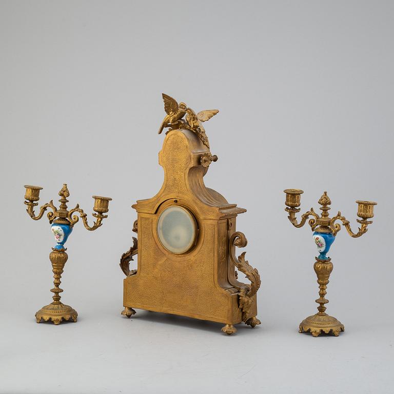 A table clock and two candelabras from the late 19th century.