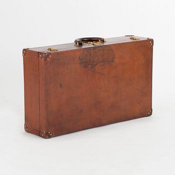 LOUIS VUITTON, a brown faux leather suitcase from around 1910.