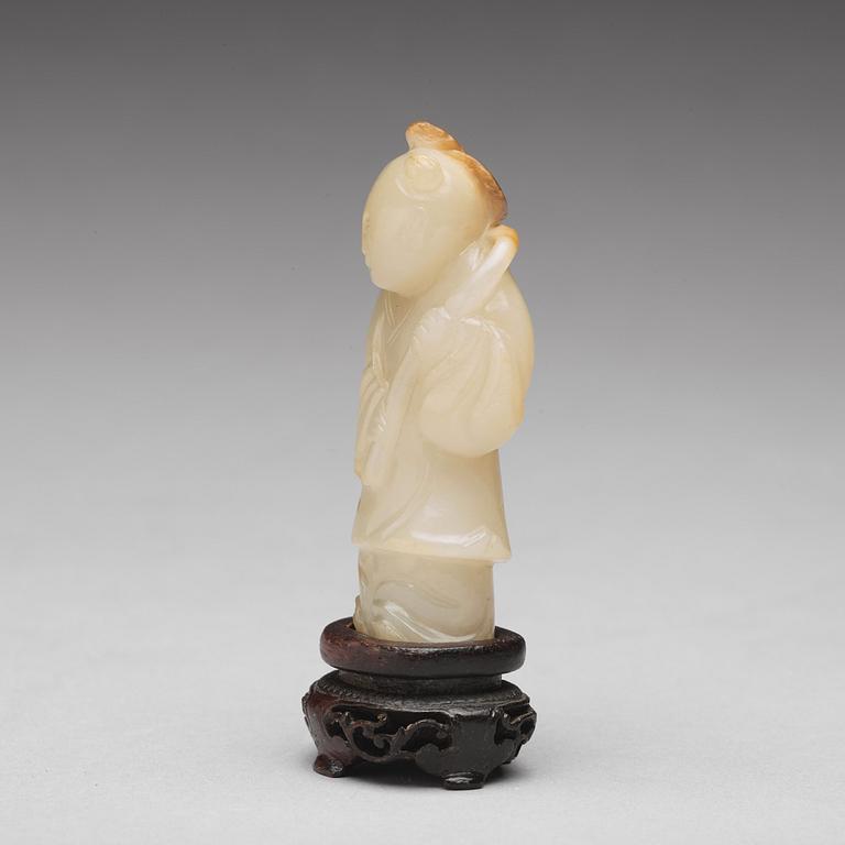 A carved nephrite figure of a boy with a lotus branch, Qing dynasty (1644-1912).