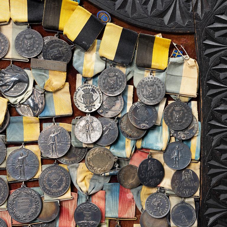Idrottsmedaljer på märkessköld. Delvis silver. Sverige 1900-talets första hälft.