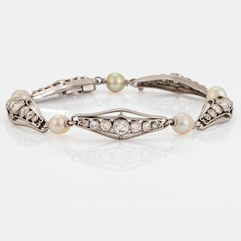 1034. A platinum bracelet set with old-cut diamonds and pearls.