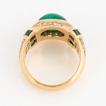 An 18K gold ring set with a cabochon-cut emerald.