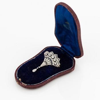 A platinum brooch with round brilliant, eight-, and rose-cut diamonds and calibré-cut sapphires.