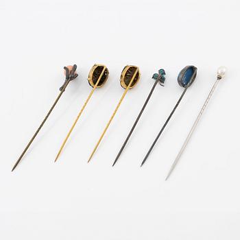 Six brooch pins in various designs and materials.
