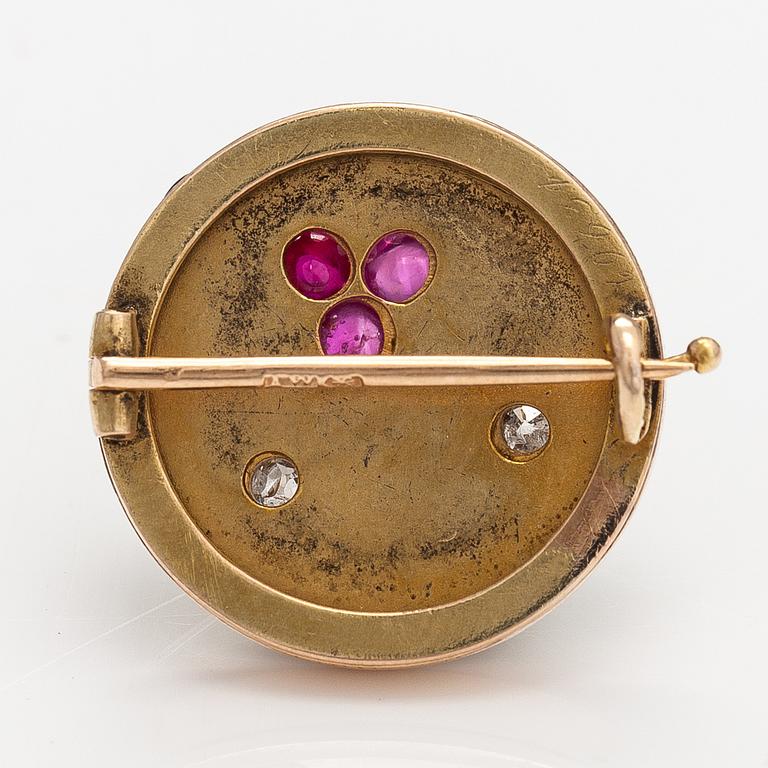 A 14k gold brooch with diamonds ca. 0.12 ct in total and rubies, of which one is synthetic.