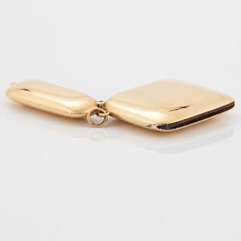 An 18K gold match case/pendant set with a faceted sapphire.