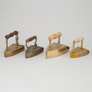 FOUR 19TH CENTURY BRASS IRONS.