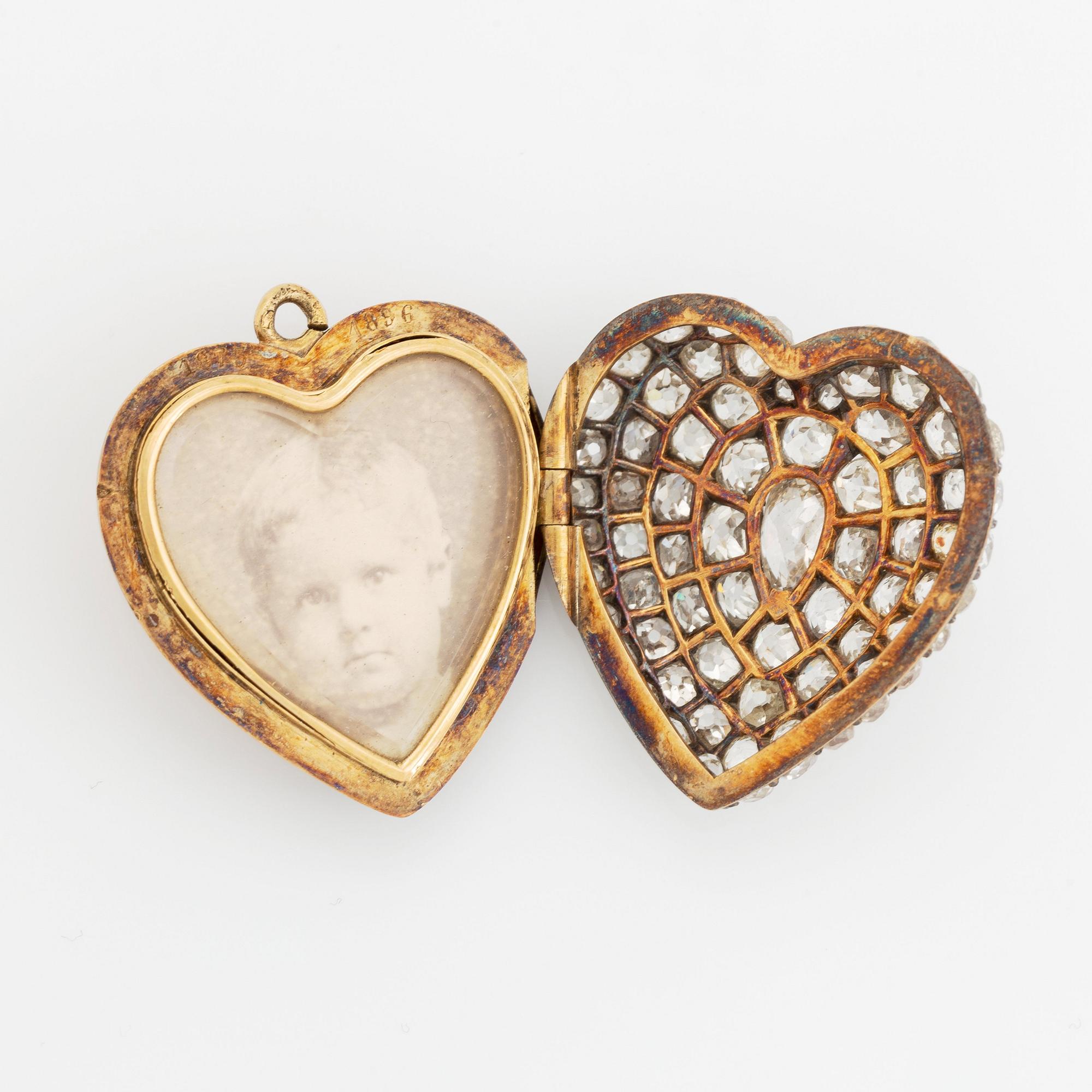 A pendant/locket in 18K gold set with old-cut diamonds, in the form of a heart.