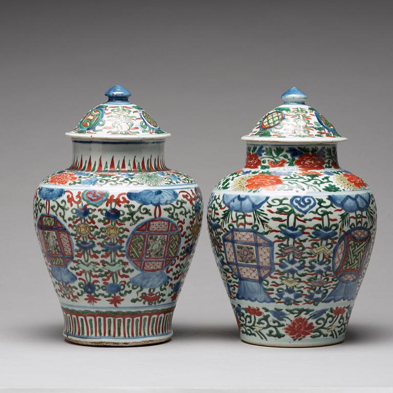 A matched pair of Transitional wucai baluster vases with covers, 17th Century.