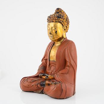 A large Vietnamese gilt and lacquered wooden buddha, circa 1900.
