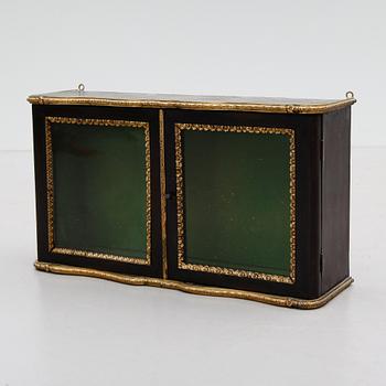 VÄGGVITRINSKÅP, omkring år 1900.