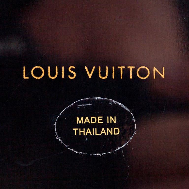 LOUIS VUITTON, a glas and plastic paper weigth.