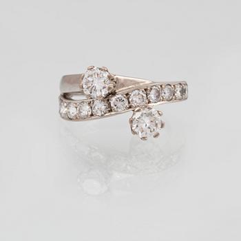 RING, 18K guld med 2 större briljantslipade diamanter ca 0.60 ct vardera samt 11 st mindre totalt ca 1.10 ct. Vikt 7,3 g.