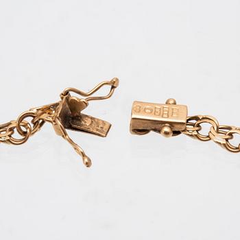 An 18K gold bracelet with a charm.