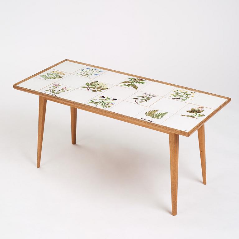 a Swedish Modern coffee table, decorated with Jobs' ceramic tiles, signed and dated 1941.