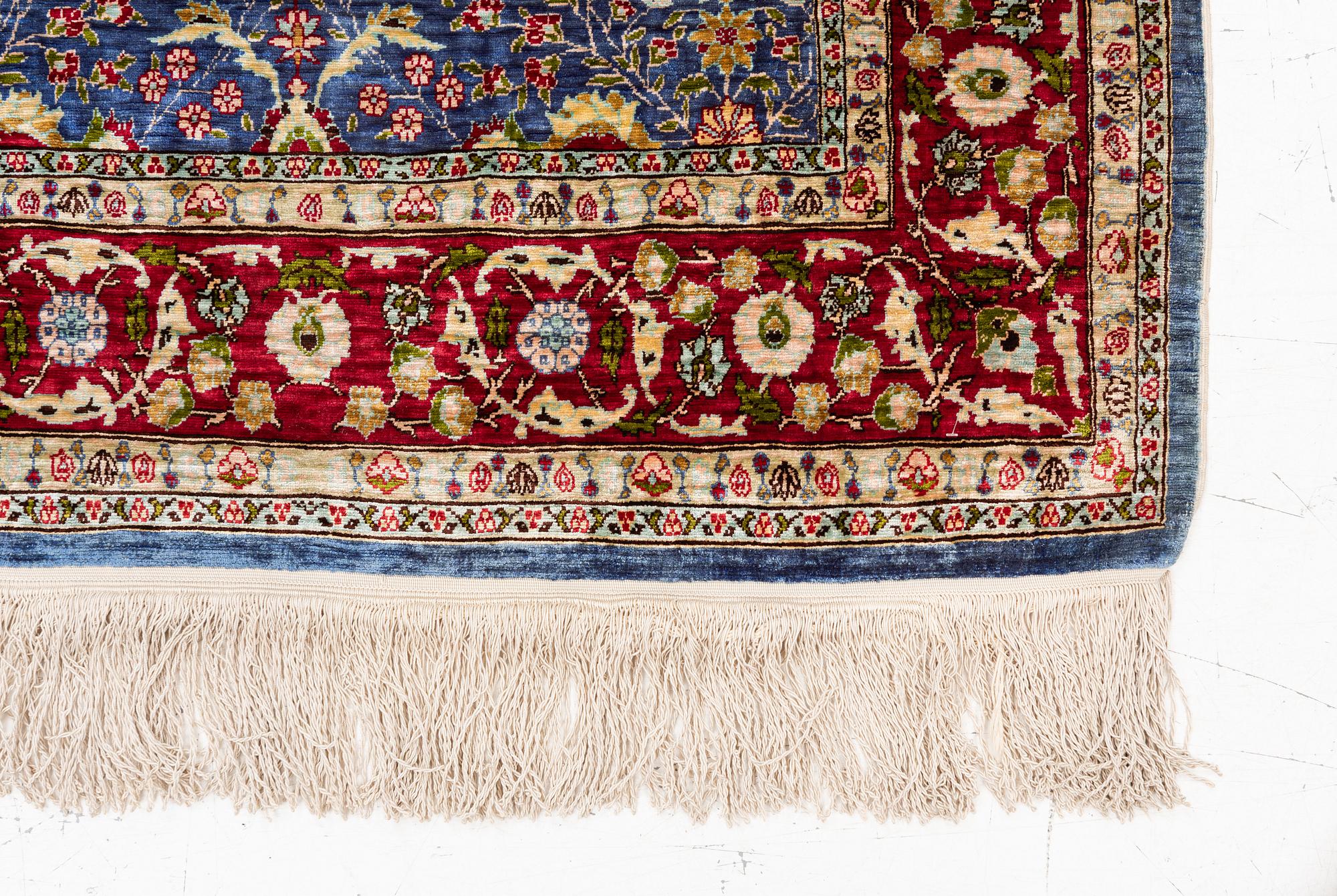 An Oriental silk rug, signed, c. 125 x 85 cm.