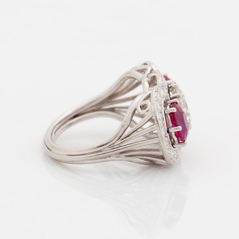 An 18K white gold ring set with faceted rubies and a round brilliant-cut diamond and eight-cut diamonds.