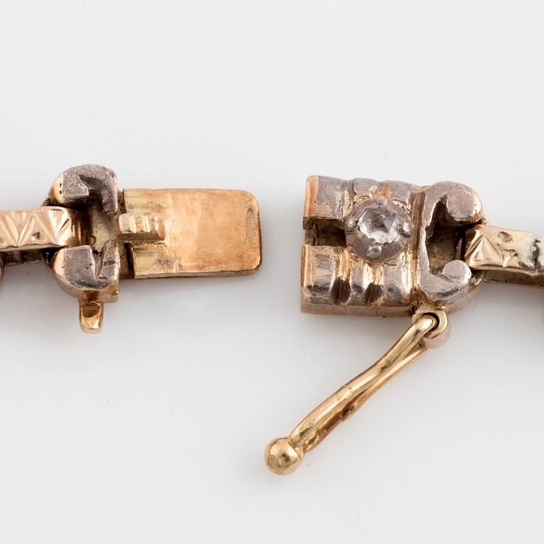 A 14K gold and silver bracelet set with an emerald and rose-cut diamonds.