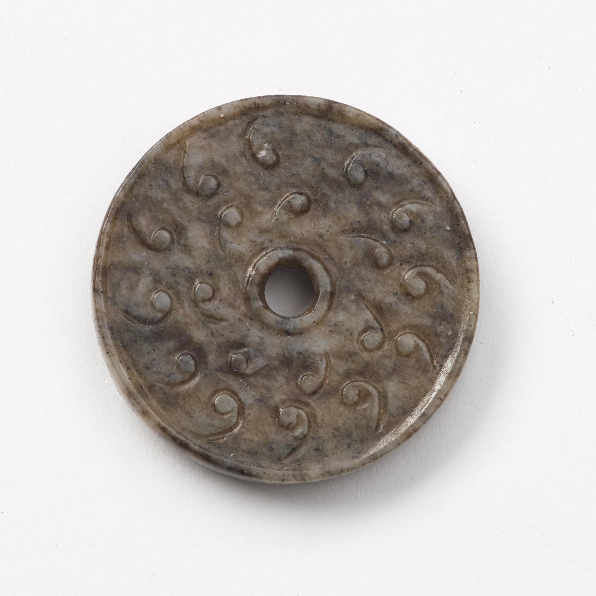 A group of three archaistic Chinese stone bi discs and two pendants.
