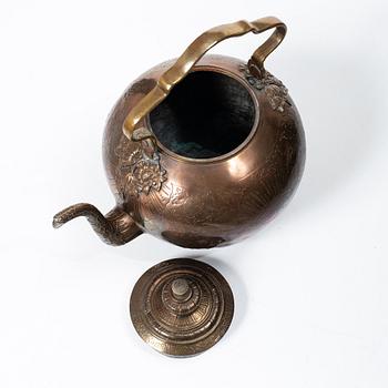 A German Rococo repoussé copper teapot on rechaud, mid 18th century.