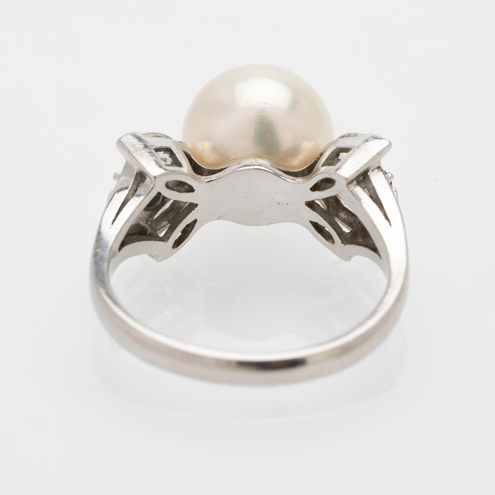 Platinum ring with a cultured pearl, emeralds and diamonds.