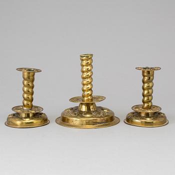 Three baroque style brass candle sticks.