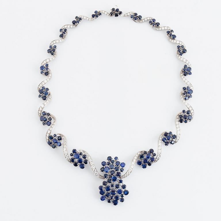 An 18K white gold necklace set with round brilliant-cut diamonds and sapphires.