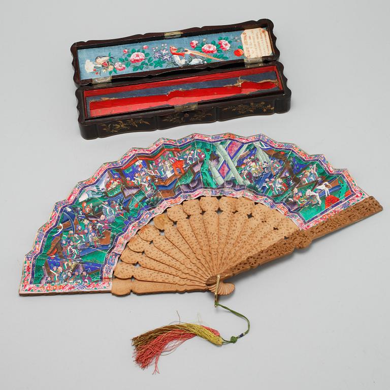 A chinese fan in a black lacquered box, Qing dynasty (1644-1912).