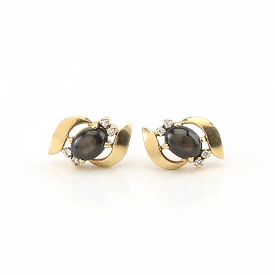 Ring and earrings in 14K gold with round brilliant-cut diamonds and likely natural black star sapphires.
