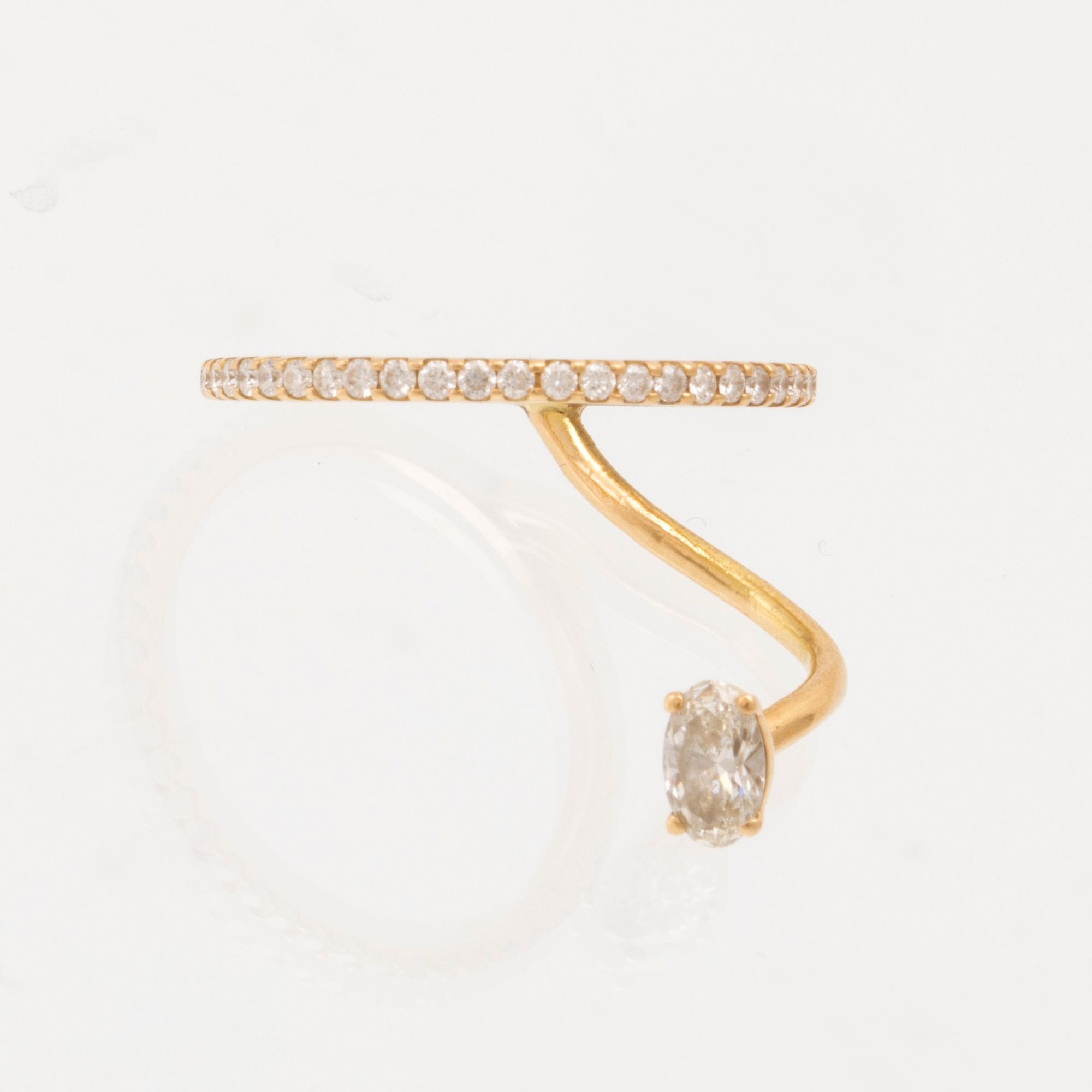 An 18K gold ring set with an oval cut and round brilliant cut diamonds by LWL Jewelry.