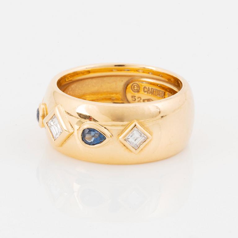 An 18K gold Cartier ring set with step-cut diamonds and faceted sapphires.