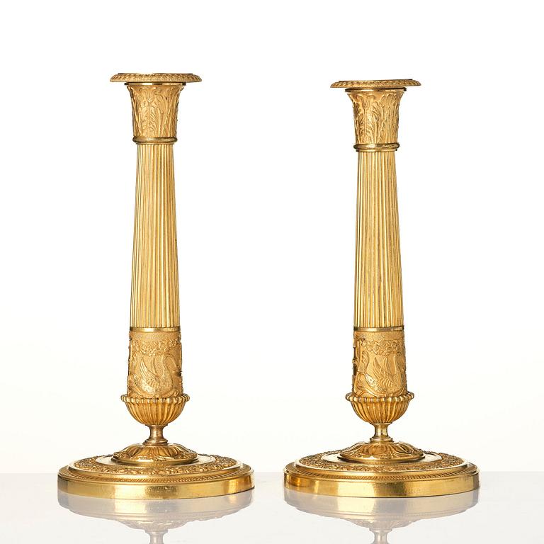 A pair of French Empire ormolu candlesticks, early 19th century.