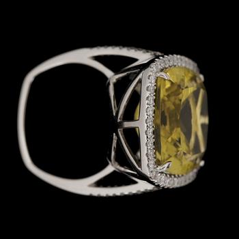 A greenish-yellow quartz ring, 14 cts, set with brilliant cut diamonds, tot. 0.64 ct.