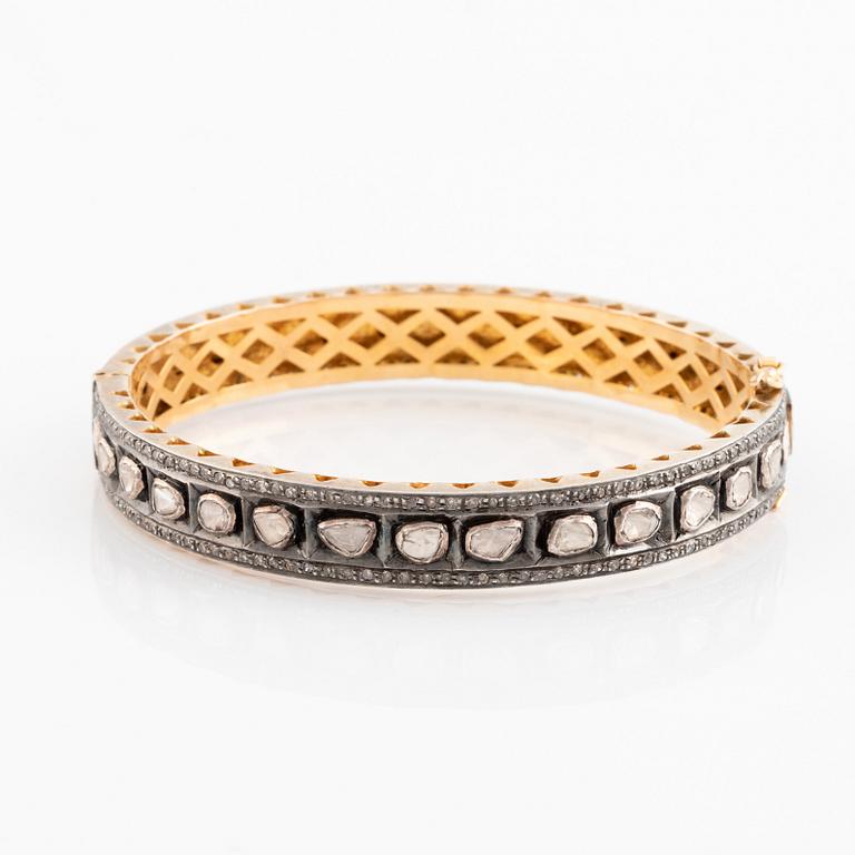 A faceted diamond bangle.