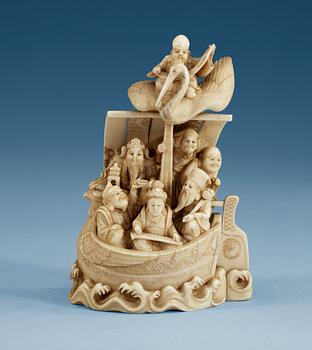 A carved sectional ivory group of Shou Lao with his crane and seven immortals in a boat, Qing dynasty, circa 1900, signed.