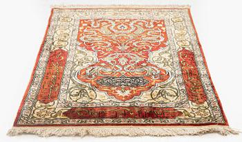 A silk and metal Hereke rug, c. 86 x 52 cm.