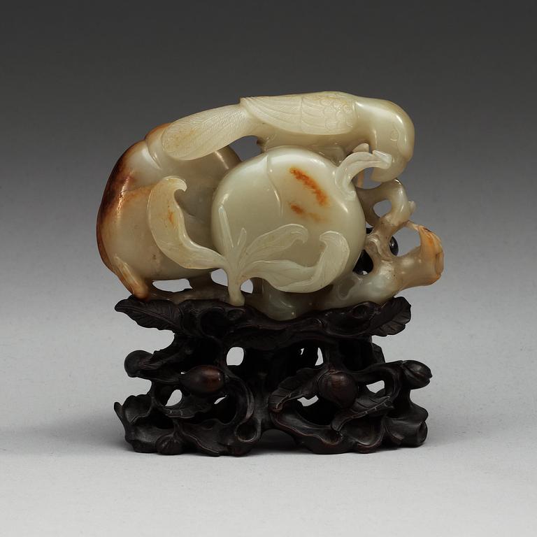 A carved nephrite figure of a parrot among peaches, Qing dynasty.
