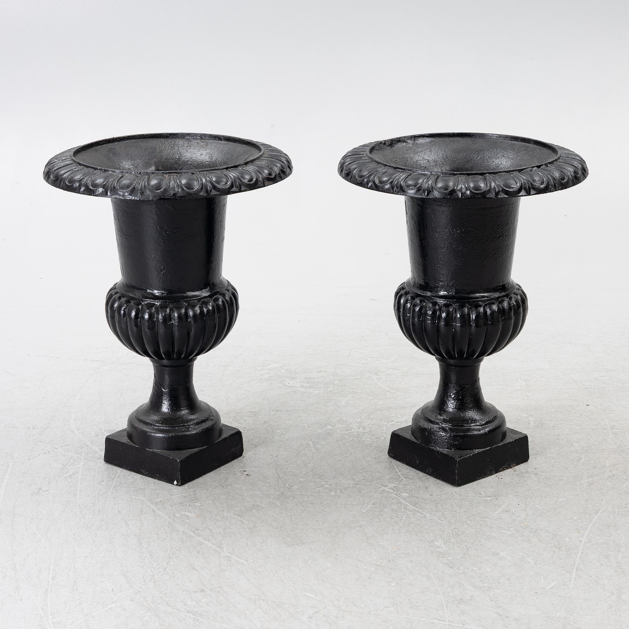 A pair of cast iron garden urns, 20th century.