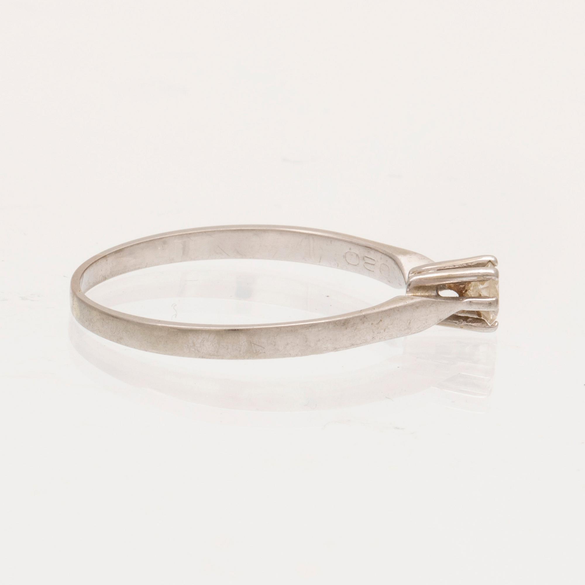 An 18K white gold ring with a round brilliant cut diamond.