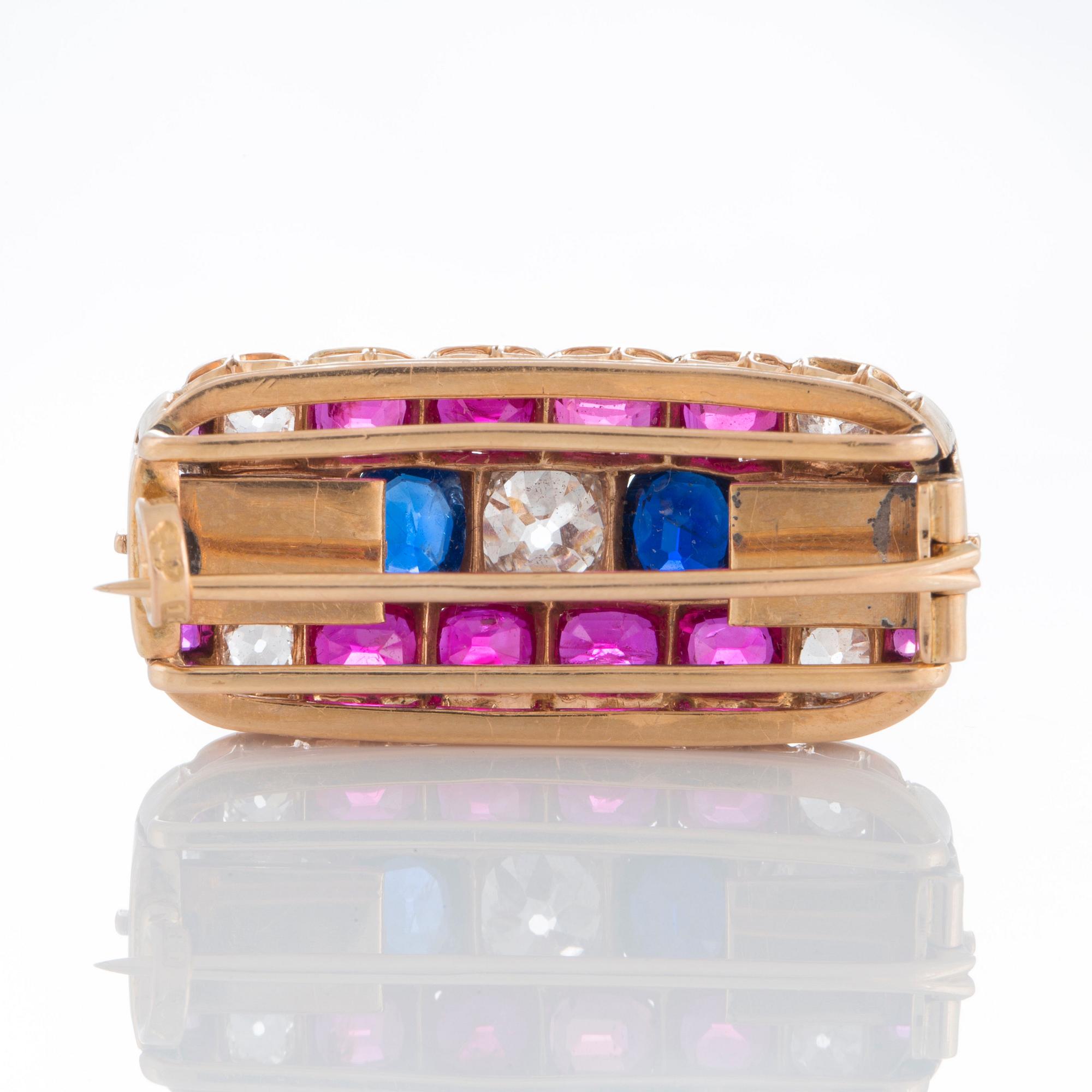 A brooch set with old-cut diamonds and faceted sapphires and rubies.