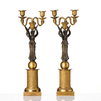 A pair of gilt and patinated bronze Empire-style two branch candelabra, later part 18th century.