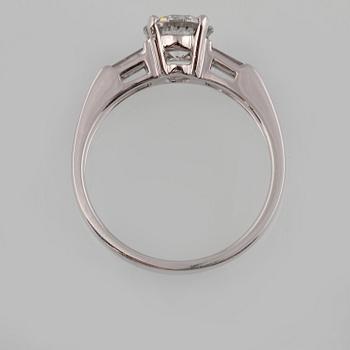 RING, 18K vitguld med briljantslipad diamant ca 1.05 ct samt 2 baguettslipade diamanter ca 0.17 ct. Vikt 3,2 gram.