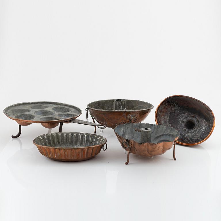 Four cake moulds, and a funnel, copper, 18th and 19th Century.
