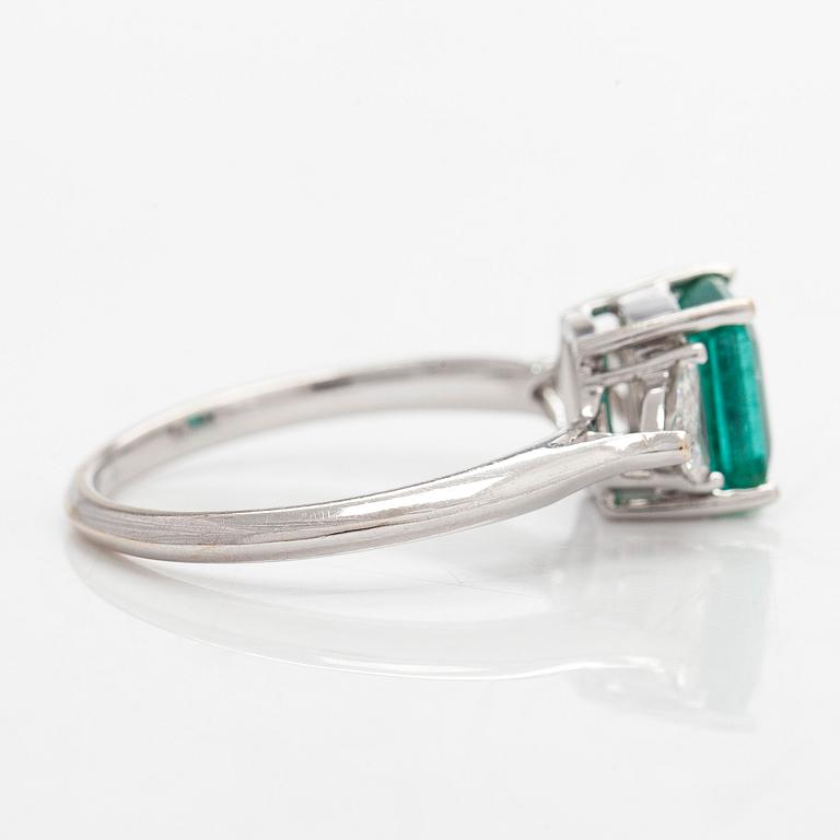 An 18K white gold ring, set with a Zambian emerald and trillion-cut diamonds.