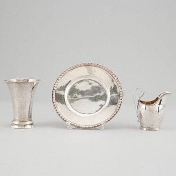 Bägare, silver, Uppsala 1835, gräddkanna, silver, I.F 1826 och assiette, silver, Stockholm 1964.