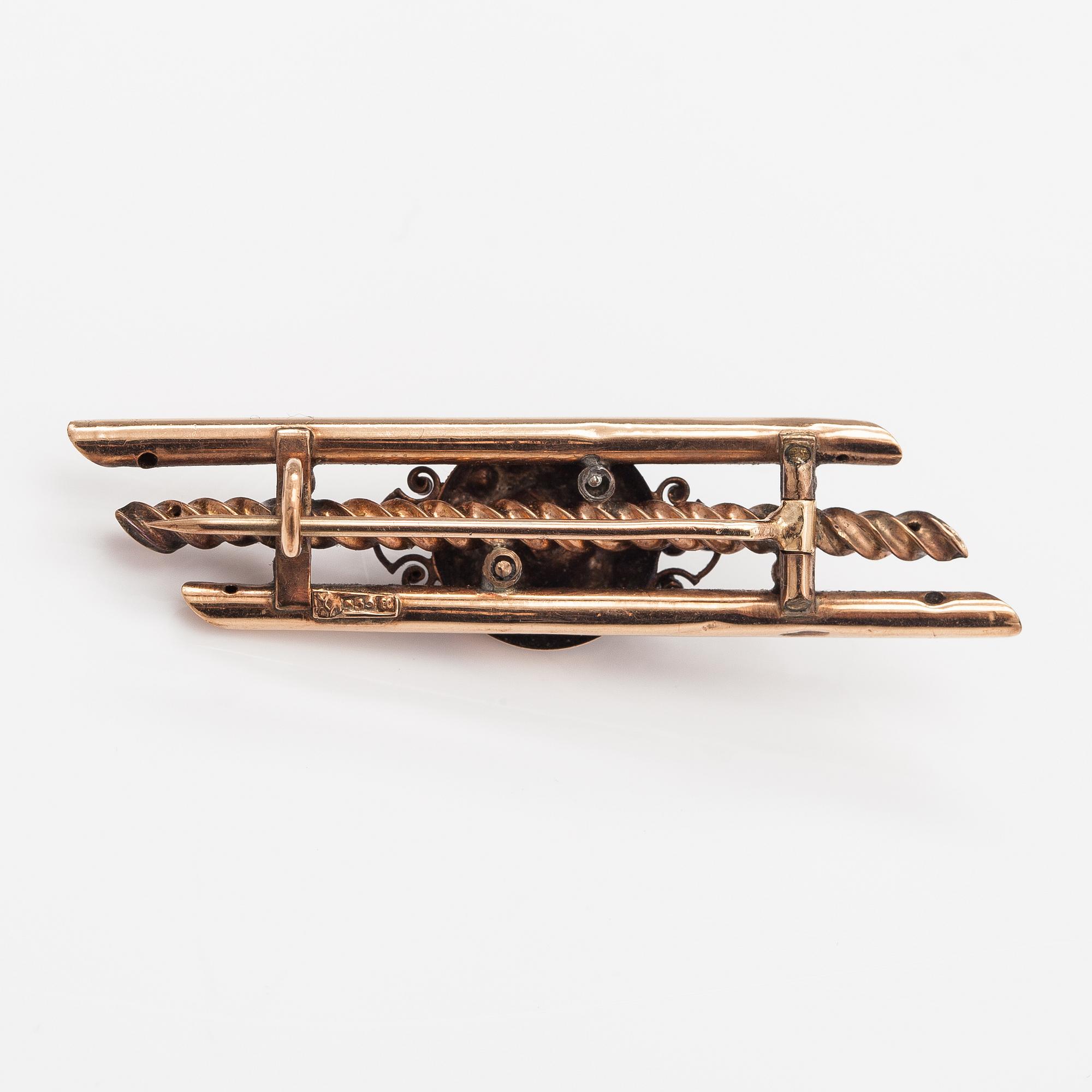 A 14K gold brooch with pearls and garnet glass doublet.